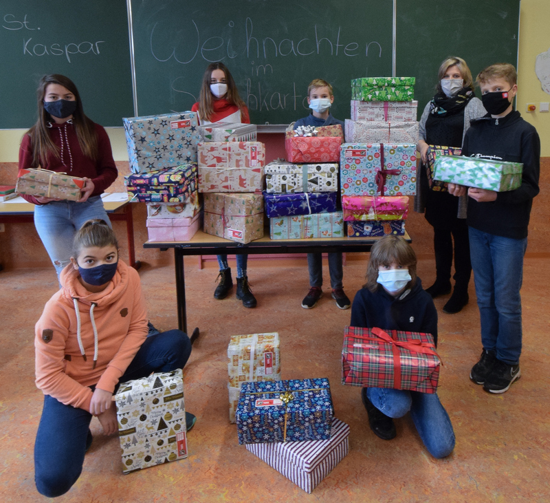 Stellvertretend für die gesamte Klasse 7b zeigen (v.l.n.r.) Stella Schwanitz, Valerie Schmitz (knieend), Lilith Münch, Finn Adden, Julian Jelitte (knieend), Klassenlehrerin Mareike Clarke und David Heising einen Teil der Päckchen.