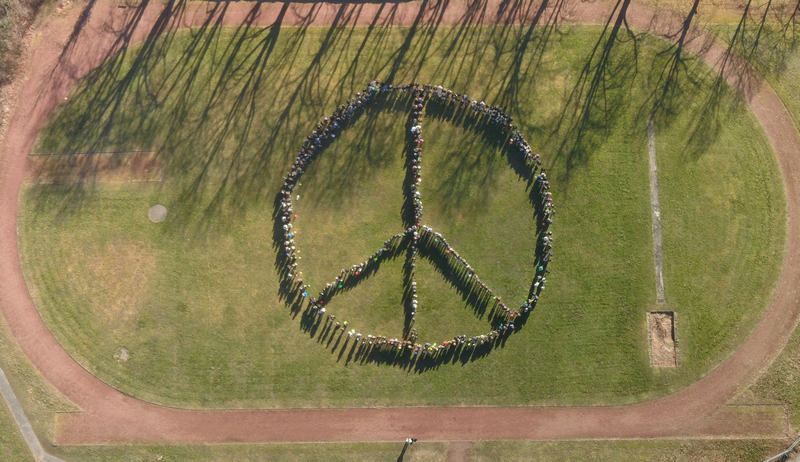Schülerinnen und Schüler setzen mit ihren Lehrern ein Zeichen für den Frieden.