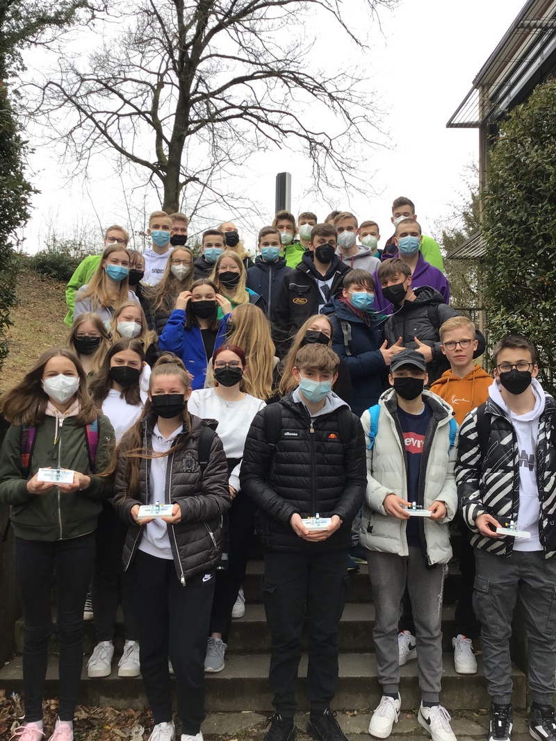 Nach einem lehrreichen Tag posieren die teilnehmenden Gymnasiasten für ein Gruppenfoto. Die Schüler in der ersten Reihe zeigen ihre Elektromotoren.