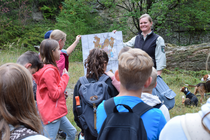Revierförsterin Marina Jürgens zeigt den Schülerinnen und Schülern der Klasse 5b auf einer Karte ihr Revier.