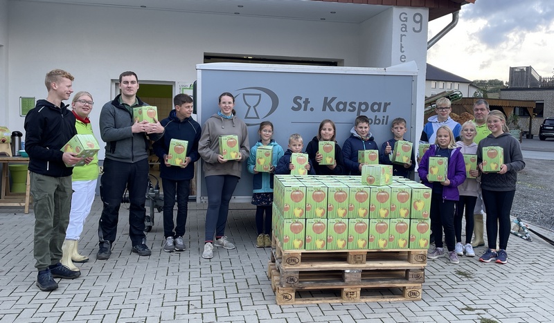 Nach einem langen Tag präsentieren die AG-Teilnehmer und weitere Helfer vor der Willebadessener Mosterei Peters den frisch gepressten Apfelsaft.