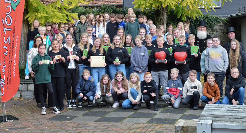 Schornsteinfegermeister Werner Überdick freut sich zusammen mit seinem Kollegen Jochen Loke über die großartige Spendenbereitschaft. Stellvertretend für die Schulgemeinschaft übergeben das Glückstour-Team um Mara Cebul, Lena Fritsche, Sina Günther, Pauline Kuhaupt, Julia Schmitz, Anna und Lennard Überdick, Marlon Bannenberg, Lennard Becker, Florian Herling, Matti Lüke, Luca Rempel und Max Koch zusammen mit den Fünftklässlern, den Lehrern Jörg Lange, Ulla Gottschalk und Annette Tisius sowie Schulleiter Matthias Nadenau die Spende.